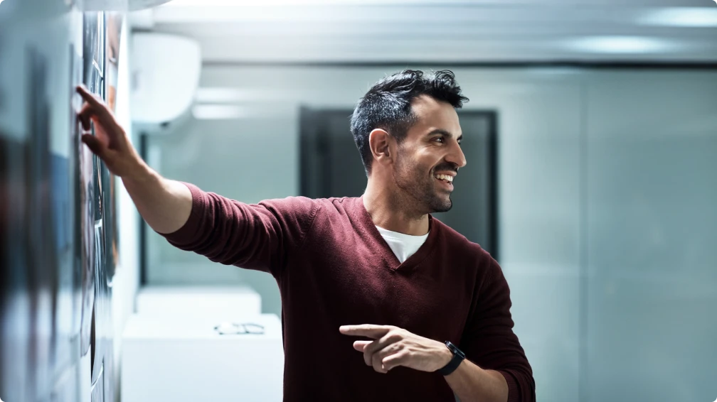 Ein Mann zeigt auf eine Tafel und lächelt