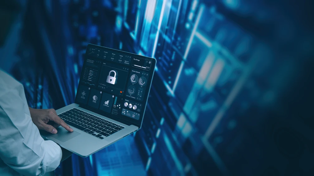 Ein Mann hält einen Laptop in der Hand und zeigt auf den Bildschirm