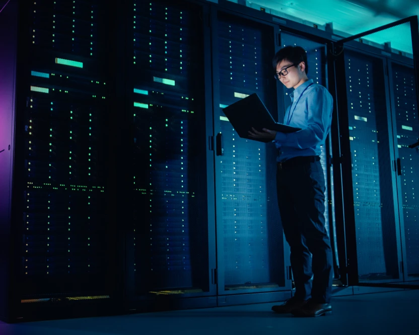 Ein mann steht in einem serverraum und schaut auf einen ordner