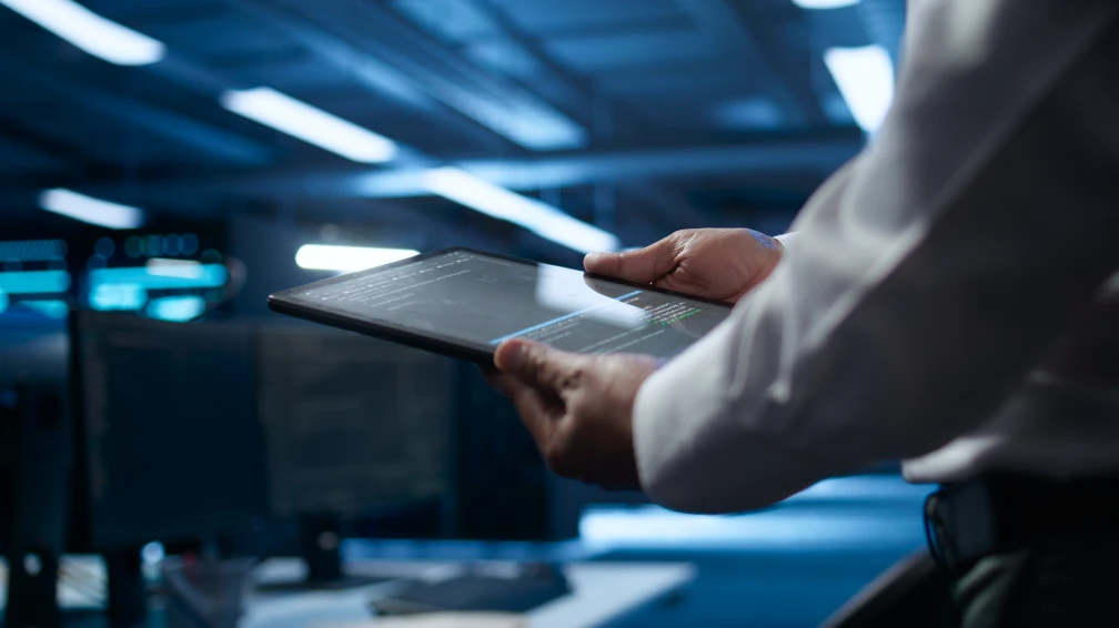 Ein Mann hält ein Tablet in den Händen und schaut darauf