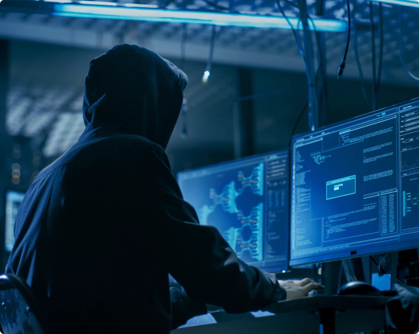 Ein Mann in einer Kapuze arbeitet an einem Computer